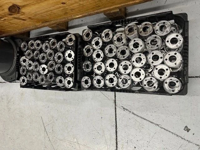 Trays of machined metal components in STS company photography
